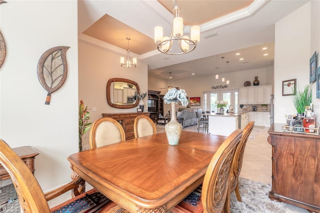 2939 Bella Flore Ter, New Smyrna Beach, FL 32168 - dining space featuring a tray ceiling, a chandelier, recessed lighting, light tile patterned floors, and a towering ceiling