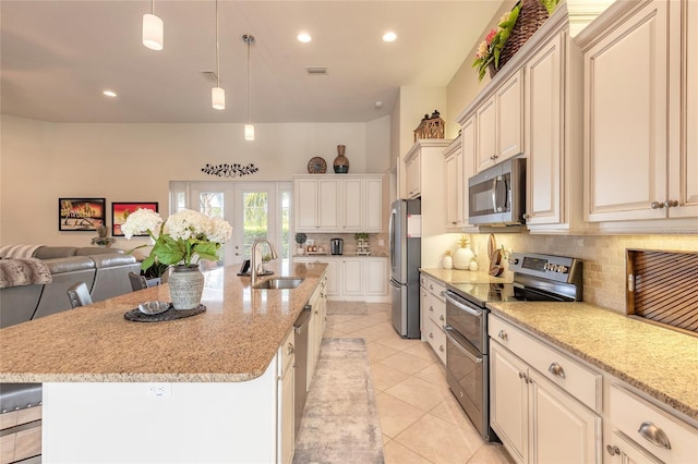 2939 Bella Flore Ter, New Smyrna Beach, FL 32168 - kitchen with appliances with stainless steel finishes, decorative backsplash, open floor plan, light stone countertops, and decorative light fixtures