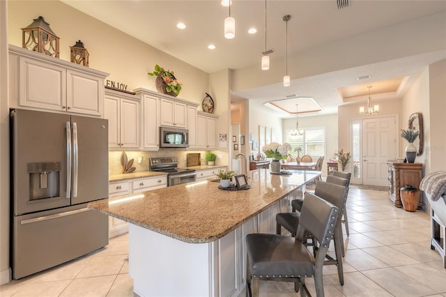 2939 Bella Flore Ter, New Smyrna Beach, FL 32168 - kitchen featuring appliances with stainless steel finishes, light tile patterned floors, backsplash, light stone countertops, and recessed lighting