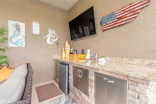 2939 Bella Flore Ter, New Smyrna Beach, FL 32168 - indoor bar with fridge and a textured wall
