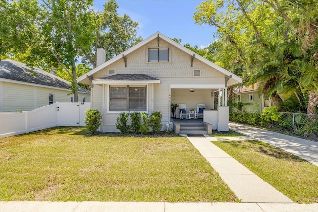 402 N Orange St, New Smyrna Beach, FL 32168 - bungalow-style house with a porch, a gate, and a chimney