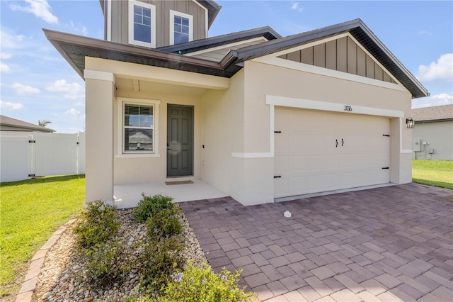3116 Crab Trap Dr, New Smyrna Beach, FL 32168 - view of front of home featuring board and batten siding, a garage, decorative driveway, and stucco siding