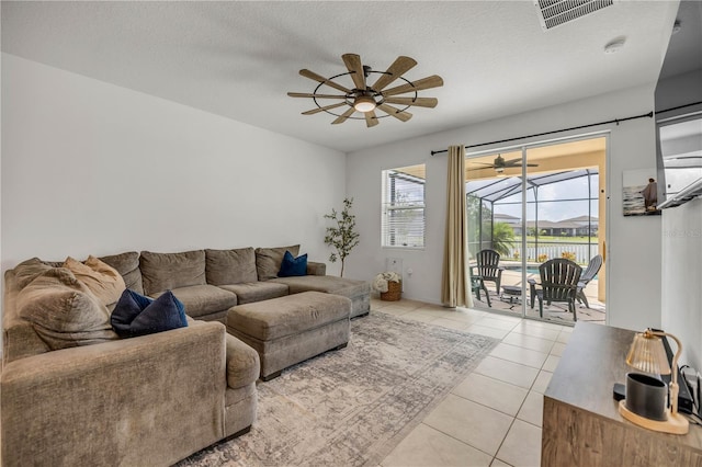 3116 Crab Trap Dr, New Smyrna Beach, FL 32168 - living room featuring a ceiling fan, light tile patterned flooring, and a textured ceiling