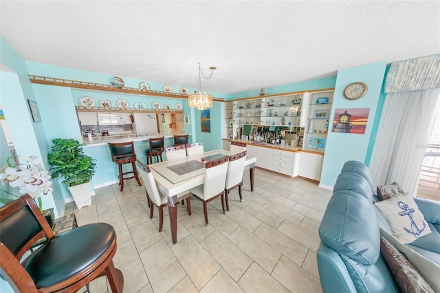 2967 S Atlantic Ave Unit 508, Daytona Beach, FL 32118 - dining area featuring a textured ceiling, a chandelier, bar, and light tile patterned flooring