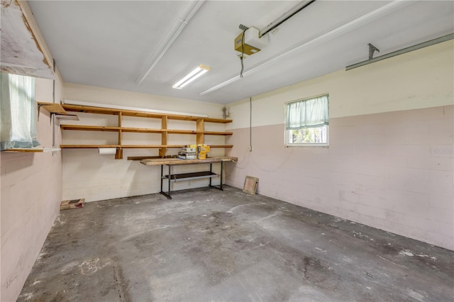 2416 Pine Tree Dr, Edgewater, FL 32141 - garage featuring a garage door opener, concrete block wall, and a workshop area