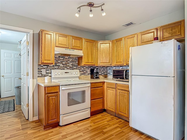 1331 Needle Palm Dr, Edgewater, FL 32132 - kitchen with white appliances, under cabinet range hood, light countertops, and light wood-style flooring