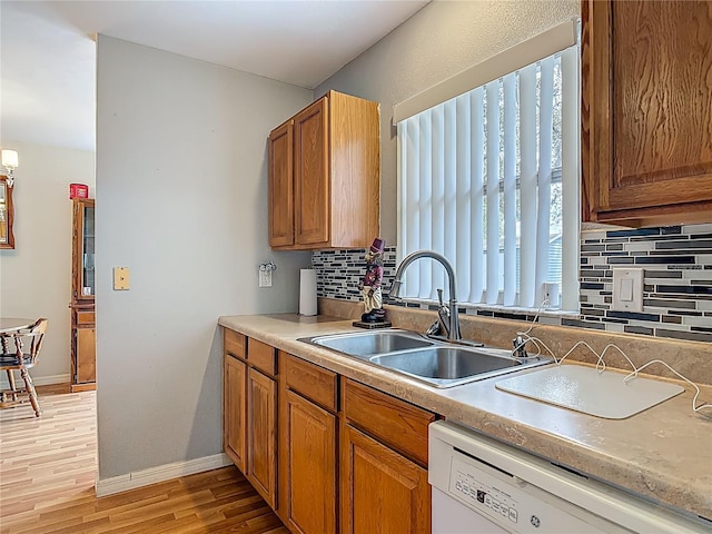 1331 Needle Palm Dr, Edgewater, FL 32132 - kitchen with dishwasher, tasteful backsplash, light wood finished floors, brown cabinetry, and light countertops