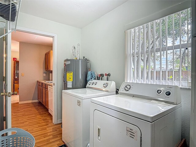 1331 Needle Palm Dr, Edgewater, FL 32132 - washroom featuring water heater, washer and dryer, light wood-type flooring, and healthy amount of natural light