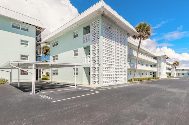 325 N Causeway Unit B305, New Smyrna Beach, FL 32169 - view of apartment building / complex featuring covered parking