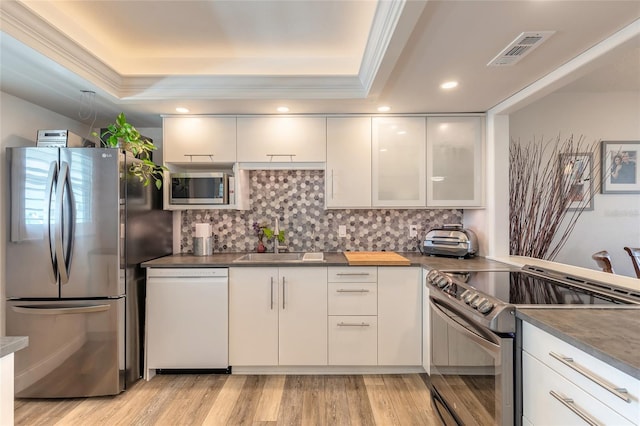 325 N Causeway Unit B305, New Smyrna Beach, FL 32169 - kitchen featuring stainless steel appliances, a tray ceiling, backsplash, crown molding, and recessed lighting