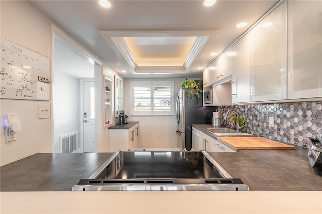 325 N Causeway Unit B305, New Smyrna Beach, FL 32169 - kitchen featuring tasteful backsplash, dark countertops, recessed lighting, white cabinetry, and range