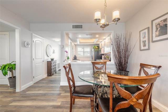 325 N Causeway Unit B305, New Smyrna Beach, FL 32169 - dining space with wood finished floors and a chandelier
