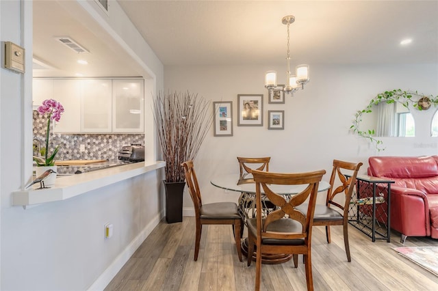 325 N Causeway Unit B305, New Smyrna Beach, FL 32169 - dining space with light wood finished floors and a chandelier