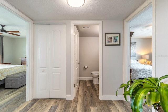 325 N Causeway Unit B305, New Smyrna Beach, FL 32169 - ensuite bathroom with a closet, wood finished floors, ceiling fan, and a textured ceiling