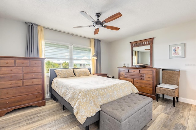 325 N Causeway Unit B305, New Smyrna Beach, FL 32169 - bedroom with light wood-style floors, a ceiling fan, and a textured ceiling