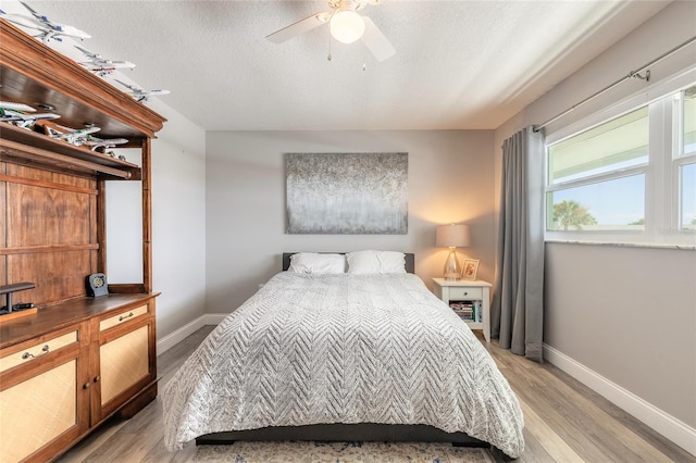 325 N Causeway Unit B305, New Smyrna Beach, FL 32169 - bedroom featuring light wood-style flooring, ceiling fan, and a textured ceiling