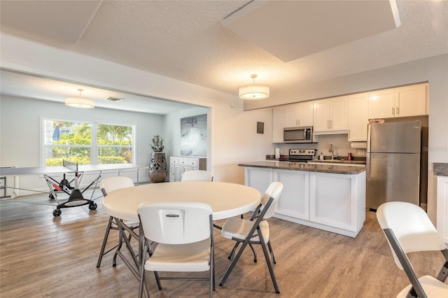 325 N Causeway Unit B305, New Smyrna Beach, FL 32169 - dining space featuring light wood finished floors and a textured ceiling