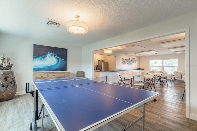 325 N Causeway Unit B305, New Smyrna Beach, FL 32169 - recreation room featuring wood finished floors and a textured ceiling