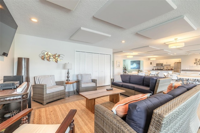 325 N Causeway Unit B305, New Smyrna Beach, FL 32169 - living room with light wood finished floors, a textured ceiling, and recessed lighting