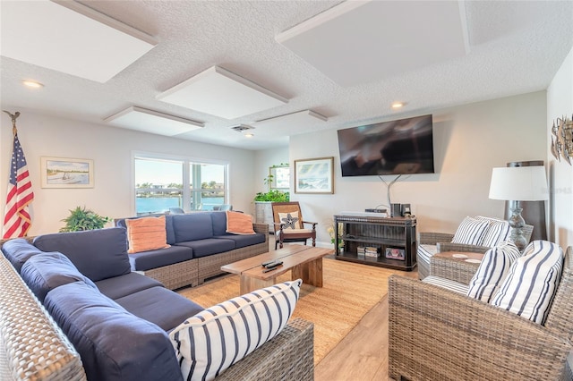 325 N Causeway Unit B305, New Smyrna Beach, FL 32169 - living room featuring a textured ceiling and light wood finished floors