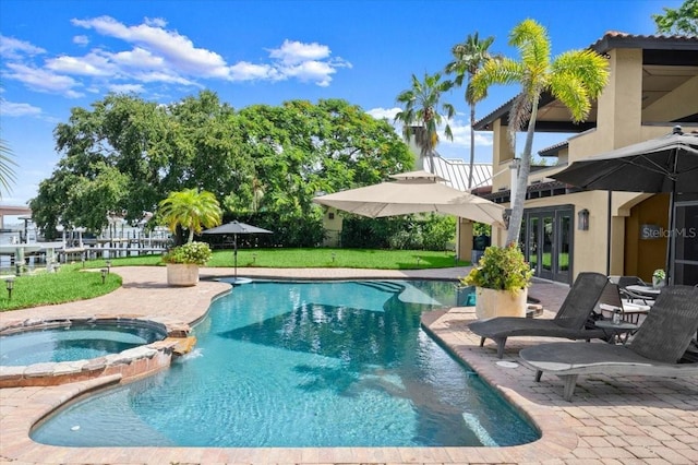 206 Canova Dr, New Smyrna Beach, FL 32169 - view of pool featuring french doors, a patio area, a pool with connected hot tub, and a lawn