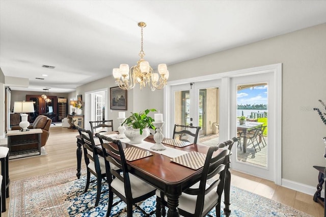 206 Canova Dr, New Smyrna Beach, FL 32169 - dining space featuring french doors, a chandelier, and light wood finished floors