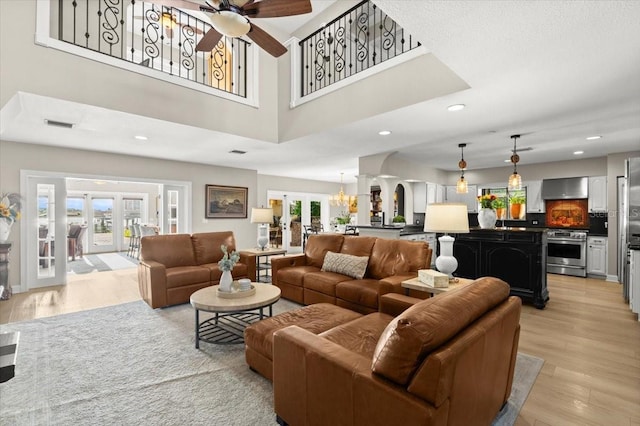 206 Canova Dr, New Smyrna Beach, FL 32169 - living room with french doors, light wood-style floors, ceiling fan, arched walkways, and recessed lighting