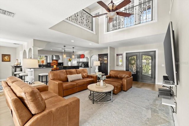 206 Canova Dr, New Smyrna Beach, FL 32169 - living room with healthy amount of natural light, ceiling fan, wood finished floors, and a towering ceiling