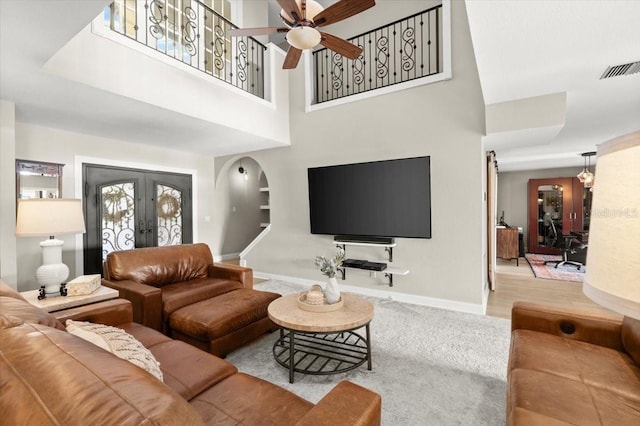 206 Canova Dr, New Smyrna Beach, FL 32169 - living room with ceiling fan, a high ceiling, french doors, and arched walkways