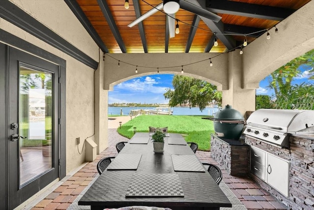 206 Canova Dr, New Smyrna Beach, FL 32169 - view of patio / terrace featuring exterior kitchen, a water view, a ceiling fan, and outdoor dining space