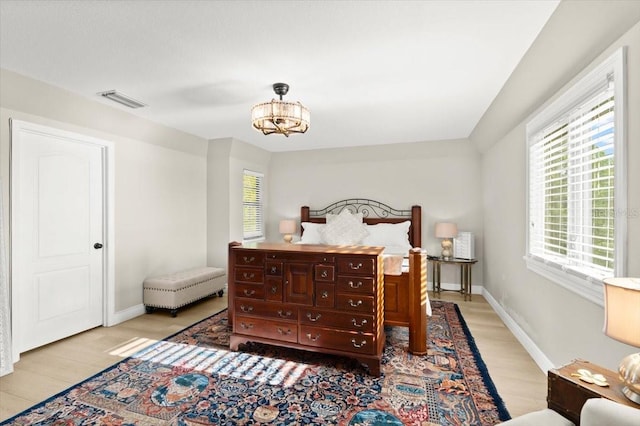 206 Canova Dr, New Smyrna Beach, FL 32169 - bedroom featuring light wood-style flooring and a chandelier