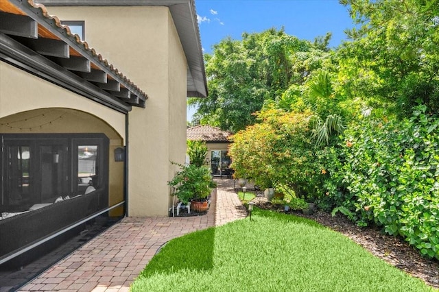 206 Canova Dr, New Smyrna Beach, FL 32169 - entrance to property featuring stucco siding, a lawn, and a tile roof