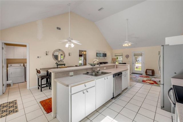 527 Old Minorcan Trl, New Smyrna Beach, FL 32168 - kitchen featuring stainless steel appliances, a ceiling fan, high vaulted ceiling, light countertops, and washing machine and clothes dryer
