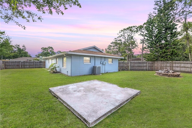 3132 Pine Tree Dr, Edgewater, FL 32141 - yard at dusk with a fenced backyard, a patio, and a fire pit