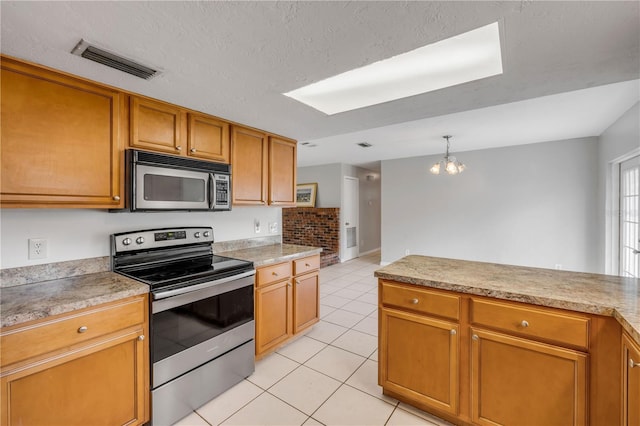 3132 Pine Tree Dr, Edgewater, FL 32141 - kitchen with appliances with stainless steel finishes, light tile patterned floors, a chandelier, brown cabinetry, and light countertops