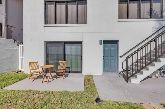 1404 N Atlantic Ave Unit 70, Daytona Beach, FL 32118 - rear view of property featuring stucco siding, a patio, and stairs