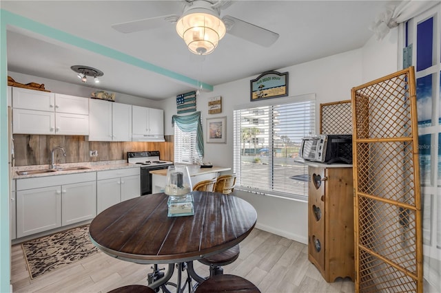 1404 N Atlantic Ave Unit 70, Daytona Beach, FL 32118 - kitchen featuring white range with electric cooktop, a ceiling fan, light wood finished floors, light countertops, and white cabinets
