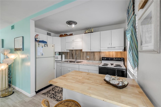 1404 N Atlantic Ave Unit 70, Daytona Beach, FL 32118 - kitchen with white appliances, under cabinet range hood, white cabinetry, and light wood-style floors