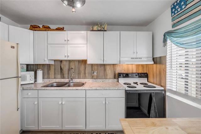 1404 N Atlantic Ave Unit 70, Daytona Beach, FL 32118 - kitchen featuring white appliances, under cabinet range hood, white cabinetry, and light stone countertops