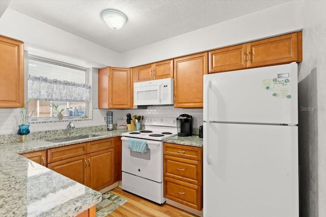 211 Fox Pl, Port Orange, FL 32127 - kitchen with white appliances, light wood-style flooring, tasteful backsplash, light stone countertops, and brown cabinets