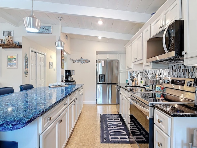 657 S Pine St, New Smyrna Beach, FL 32169 - kitchen with appliances with stainless steel finishes, white cabinetry, dark stone countertops, pendant lighting, and tasteful backsplash