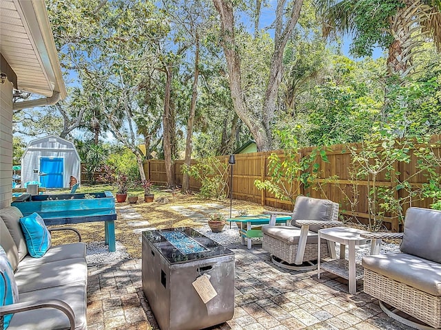 657 S Pine St, New Smyrna Beach, FL 32169 - fenced backyard with a patio, a storage shed, and an outdoor living space with a fire pit