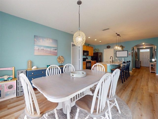 2731 Star Coral Ln, New Smyrna Beach, FL 32168 - dining area with arched walkways and light wood-style floors