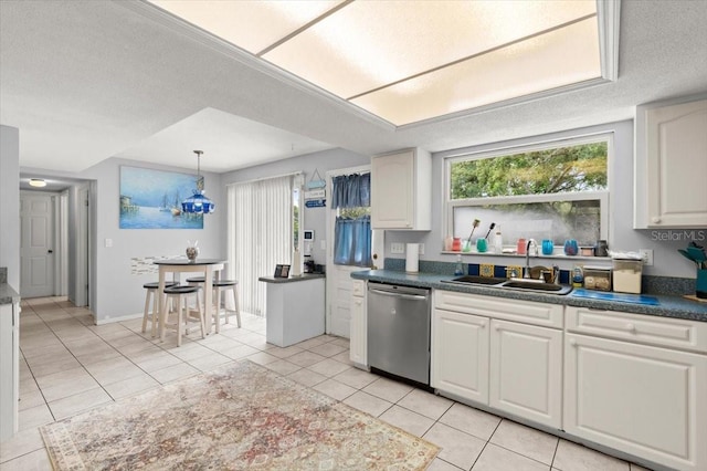 20 Putnam Ave, Ormond Beach, FL 32174 - kitchen featuring dishwasher, healthy amount of natural light, light tile patterned flooring, white cabinetry, and a textured ceiling