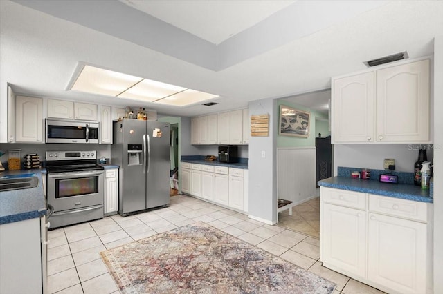 20 Putnam Ave, Ormond Beach, FL 32174 - kitchen featuring stainless steel appliances, light tile patterned floors, and dark countertops