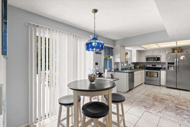 20 Putnam Ave, Ormond Beach, FL 32174 - kitchen with appliances with stainless steel finishes, light tile patterned flooring, dark countertops, and hanging light fixtures