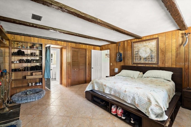 20 Putnam Ave, Ormond Beach, FL 32174 - bedroom with beam ceiling, wooden walls, a closet, and light tile patterned floors