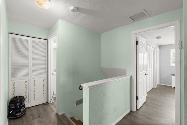 20 Putnam Ave, Ormond Beach, FL 32174 - hallway featuring an upstairs landing, wood finished floors, and a textured ceiling