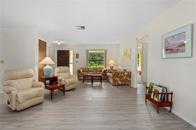 living area featuring light wood-style floors and baseboards