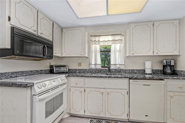 kitchen with white appliances and dark stone counters